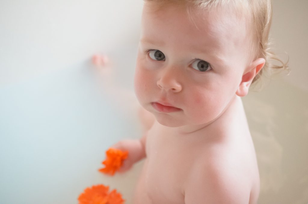 Breast milk bath, Jonah looking a bit grumpy holding his calendula flowers